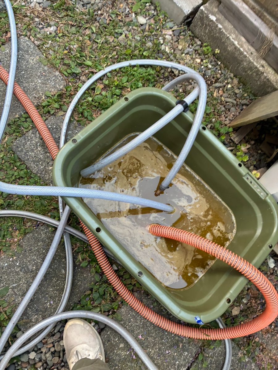 洗浄中の桶。循環させた洗浄液に溶け出した鉄分で、液が茶色く濁っている